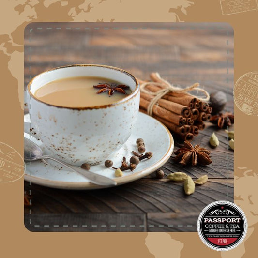 Cup of traditional chai black tea with spices including cinnamon, cloves, cardamom, and ginger, on wooden table.