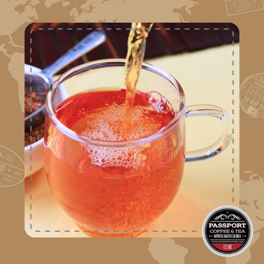 Tropicana Black Tea in a clear glass cup with rich amber color being poured, showcasing its floral and fruity infusion.