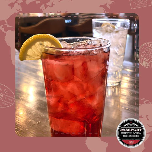 Sweet Scarlet Hibiscus Tea with lemongrass and berry infusion in a glass with lemon slice.