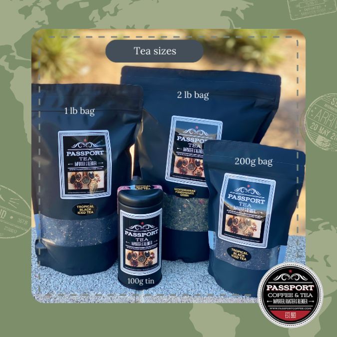 Various sizes of Passport Coffee & Tea Wild Strawberry Black Tea bags and tin displayed outdoors.